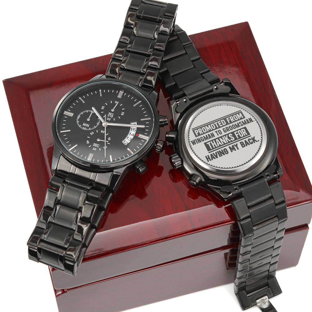 Two black metal watches on a wood box, one engraved Promoted From Wingman to Groomsman. Thanks For Having My Back.